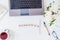 Top view light working place with laptop keyboard,notebook with Plenning lettering, cup of tea, sletchbook, glasses, white peony o