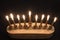 Top view of a lighted Hanukkah menorah against a black background