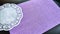 Top view of lilac or purple sheet of velvet paper and white openwork carved napkin. Abstract frame, background and