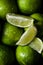 Top view of the lime slices on a heap of freshly washed limes in bright light
