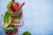 Top view Lime and strawberry Detox in glass mason jar on rustic background. Copy space