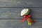Top view of little bouquet of white snowdrops tired up with red ribbon on dark grey wooden background, lots of copy space,
