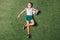 Top view of little boy holding soccer ball on grass