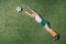 Top view of little boy pretending playing soccer on grass