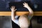 Top view of little boy sits at a computer and holds a keyboard in his hands