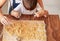 Top view of little child making homemade cookies together with mother at home.