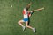 Top view of little girl pretending playing baseball on grass