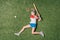 Top view of little girl pretending playing baseball on grass