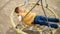 Top view on the little smiling boy lying in web rope swing and looking up on the sky. Active child, sports and development, kids