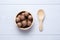 Top view macadamia in wooden bowl on white wooden table