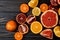 Top view, macro. An abundance of sliced colorful citrus fruits. Dark wooden background