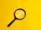 Top view magnifying glass isolated on yellow background.