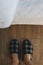 Top view of male feet in plaid slippers in bedroom