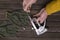 Top view of male hands, metal staple gun, gloves on the wooden surface.Process of preparation for fixing furniture