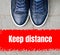 Top view on male navy blue sneakers standing on the pavement in front of the red line.Keep distance concept.Social isolation and