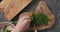Top view man hands chop fresh dill on concrete countertop