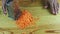 Top view on man by hands grate small slices of fresh carrot on metal grater