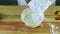 Top view on man hands pour white flour into soft dough in deep plastic bowl