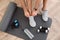 Top view of man putting on sneakers, yoga mat, bottle, skipping rope and dumbbells