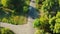 Top view of a man rides on vintage scooter in the park. Drone following motorcyclist driving on park road