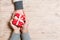 Top view of a man and a woman congratulating each other with a gift on wooden background. Surprise for a holiday concept. Copy