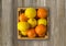 Top view. Mandarins and lemons in a wooden box with copy space for text. Fresh tangerines and lemons on a wooden background. Ripe