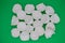 Top view of many broken white eggshells on a green background