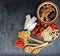 Top view of many chinese herbs with bowl of clear soup on black