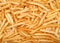 Top view many french fries on a light wood table