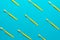 Top view of many new yellow plastic toothbrushes over turquoise blue background
