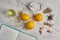 Top view of a marble table with a notebook with a recipe, lemon, garlic, and spices