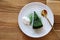 Top view Matcha green tea cake with whipping cream in the white plate on wooden table background. Japanese dessert concept