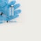 Top view of medicine bottle, blue rubber gloves, syringes on grey background. Coronavirus vaccine development. 2019-nCoV