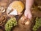 Top view of men`s hand holding a glass of wine next to various cheeses