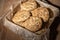 Top view of metal box with paper and chocolate cookies, dark light, on wooden table