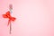 Top view of metal fork with red bow on pink background. space for text. Christmas, New Year, Birthday food, holidays, celebration