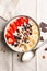 Top view of millet porridge with fruit, nuts and chocolate