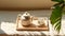 Top view of minimal, beautiful white ceramic teapot, two cups, candle on brown wooden tray on cream tablecloth in sunlight