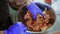 Top view of mixing pieces of meat and onion with spicies in a bowl