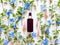 Top view of mockup of unbranded brown plastic spray bottle and floral decor - fresh greens, blue and pink flowers on a white
