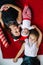 Top view of mother and her little two children lying on carpet on the eve of Christmas. Closeup