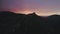 Top view of mountain on background of purple sunset sky. Action. Dark silhouettes of mountains on background sunset sky