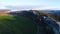 Top view of mountain landscape with green fields in evening sun. Shot. Beautiful mountain area with stone rock green