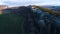 Top view of mountain landscape with green fields in evening sun. Shot. Beautiful mountain area with stone rock green