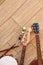 Top view of musical instruments: guitars, drums with sticks lying on light wooden background