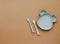 Top view neutral baby tableware on brown background, flat lay