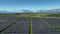 Top view of a new solar farm. Rows of modern photovoltaic solar panels next to the green field.