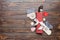 Top view of New Year dinner on wooden background. Festive cutlery on napkin with christmas decorations and toys. Family holiday