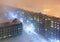 Top view of the night city. Snowfall and foggy mist on a cold winter late evening in the arctic