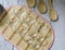 Top view of nine empty glass bowls and three wooden spoons on a white wooden plank background.